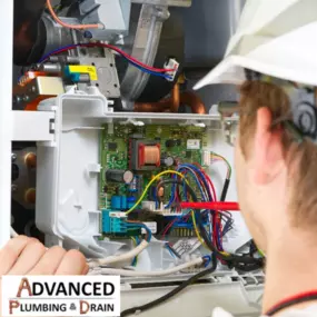 An Advanced Plumbing & Drain technician inspects and repairs the internal circuit board of a high-efficiency water heater or HVAC system, ensuring optimal electrical performance.