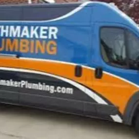 A van with a wrap on it that says 'Pathmaker Plumbing' sitting in the driveway of a home in Charlotte, NC.