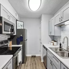 A kitchen with white cabinets and stainless steel appliances