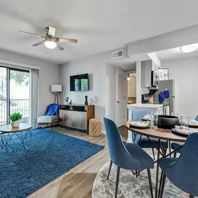 A living room and dining room with a sliding glass door