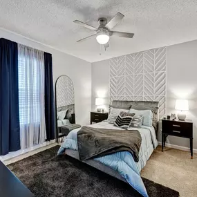 A bedroom with a bed and a ceiling fan