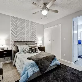 A bedroom with a large bed and a ceiling fan