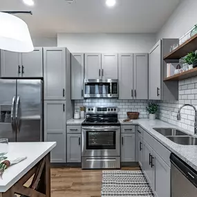 A kitchen with white cabinets and stainless steel appliances