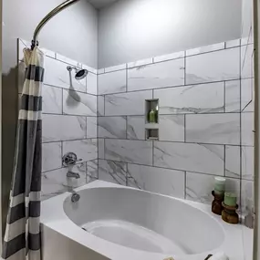 A white bathroom with a tub and a shower curtain