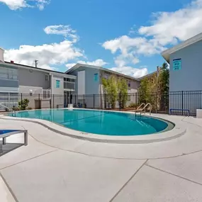 A swimming pool and a patio with chairs