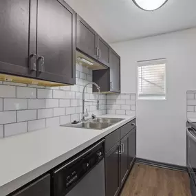 A kitchen with a sink and a refrigerator