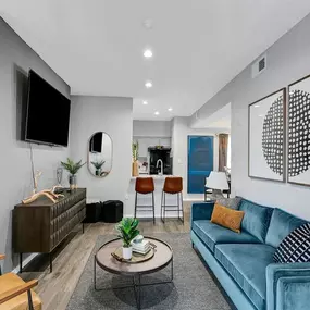 A living room with a blue couch and a tv
