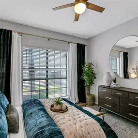 A bedroom with a bed and a ceiling fan