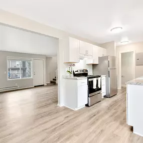 A modern kitchen with white appliances and cabinets.