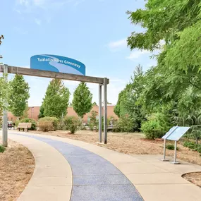 A sign for the Tualatin River Greenway is displayed above a walkway.