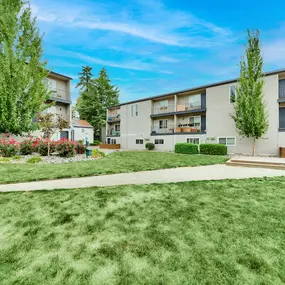 A sunny day at a residential area with apartment buildings and green lawns.