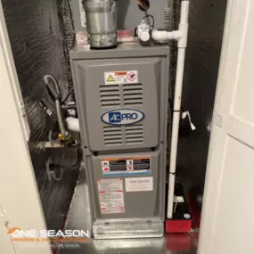 A newly installed AC Pro furnace system is neatly set up in a residential utility closet by One Season Heating & Air Conditioning.