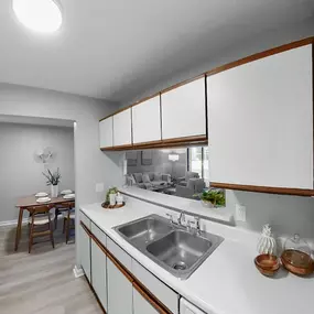 a kitchen with white counter tops and a stainless steel sink