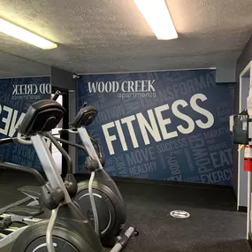 a spin bike in a gym at Wood Creek Apartments