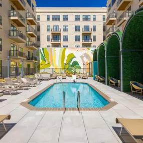 A pool surrounded by lounge chairs and umbrellas.