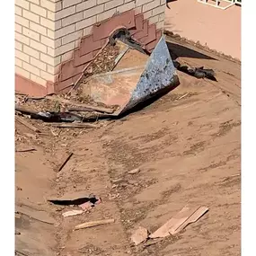 a broken metal corner positioned next to a brick wall. It suggests an area undergoing construction or demolition.