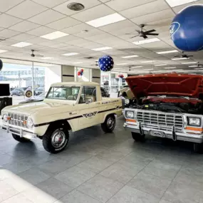 The showroom of Downtown Ford featuring vintage Ford truck models in cream and red.