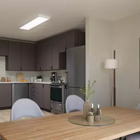 The interior view of an apartment showing a table with grey furniture and grey kitchen cabinetry