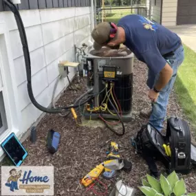Home Plumbing, Heating & Cooling technician servicing an outdoor AC unit.