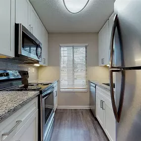 A kitchen with a stove top oven and a microwave above it.