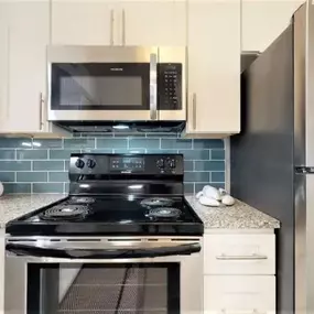 A kitchen with a black stove top oven and a black refrigerator.
