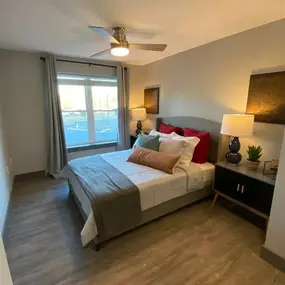 A bedroom with a large bed and a ceiling fan.