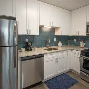 A modern kitchen with a stainless steel refrigerator, microwave, oven, and sink.