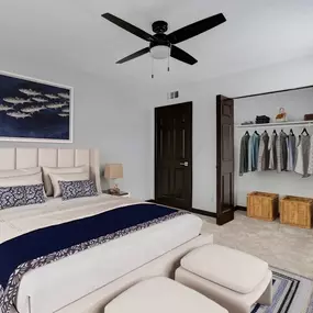 A bedroom with a bed and a ceiling fan