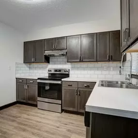 An empty kitchen with wooden cabinets and a sink
