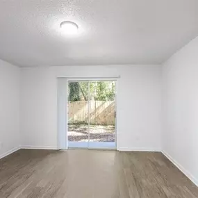 A room with a sliding glass door leading to a backyard.