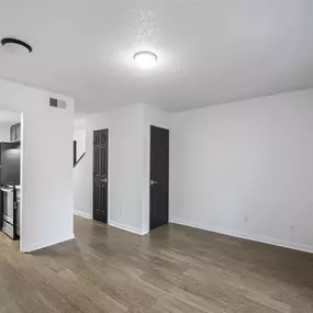 A room with a black door and a white wall.