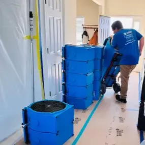 Team member from First Response Restoration of RGV setting up air movers in a home in the Rio Grande Valley. Wearing a branded blue uniform, this image highlights our 24/7 water damage and flood restoration services in McAllen, Brownsville, and beyond. IICRC certified (#70221362). Call (956) 305-4229 for immediate help.