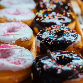 A variety of doughnuts in a display case.
