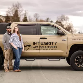 Lucas and Taylor standing next to the Integrity Air Solutions service truck