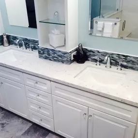 An exterior shot of a house shows a new sliding glass door installed in an extension with horizontal light brown siding. A ladder leans against the house on the left.