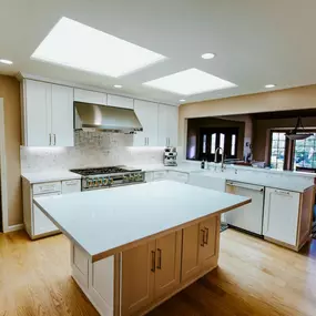 A professional is mulching an overgrown wooded area with a yellow Vermeer S925TX mini skid steer. Trees stand in the background, and the ground is covered in wood chips.