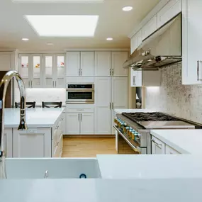 A professional is mulching an overgrown wooded area with a yellow Vermeer S925TX mini skid steer. Trees stand in the background, and the ground is covered in wood chips.