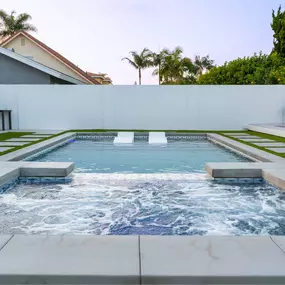 Straight-ahead shot of a custom swimming pool with built-in spa and surrounding landscape.