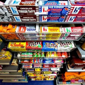 A well-stocked retail candy display featuring bulk candy and wholesale chocolate, including nostalgic brands like Turkish Taffy, M&M's, and Goodbar.A variety of bulk candy options available for wholesale distributors, perfect for convenience stores, gift shops, hotels and specialty retailers looking to stock wholesale candy.