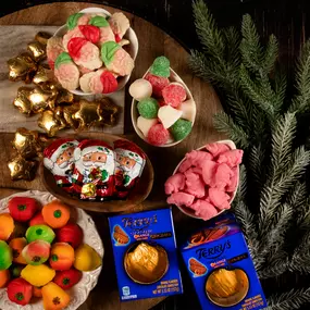Festive Christmas candy display with chocolate Santas, fruit gummies, chocolate oranges, and holiday gumdrops.