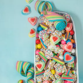 A colorful assortment of Valentine’s Day candies, including heart-shaped gummies, rainbow belts, and chocolate drops