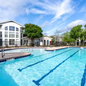Relax and unwind at the resort-style pool at Lakeline Apartments, featuring spacious lounge areas, and lush landscaping—perfect for sunny days in Leander, TX.