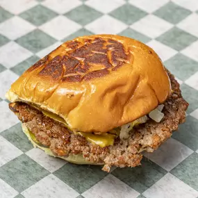 Single Impossible patty served with American cheese, grilled onions, pickles and house sauce on a Martin's potato bun