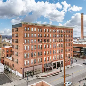 A large red brick building with a parking lot in front