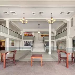 A large room with tables and chairs and a staircase