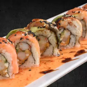 Shrimp tempura, krab stick, cream cheese and cucumber inside, smoked salmon, baked eel and avocado outside, topped with sweet chili, eel sauce and sesame seeds.