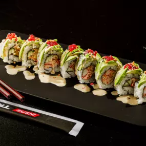 Lobster and cucumber inside, topped with layered avocado, tobiko, crunchy flakes, sesame seeds and a ginger dressing sauce