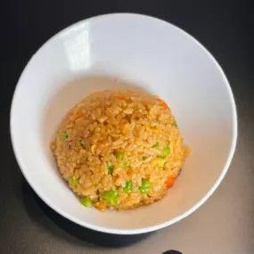 White Rice stir-fried with garlic butter, soy sauce, egg, peas, carrots and teriyaki sauce.