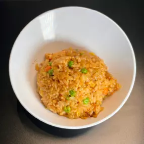White Rice stir-fried with garlic butter, soy sauce, chicken, egg, peas, carrots and teriyaki sauce.