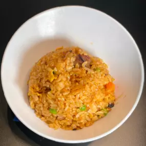 White Rice stir-fried with garlic butter, soy sauce, steak, egg, peas, carrots and teriyaki sauce.